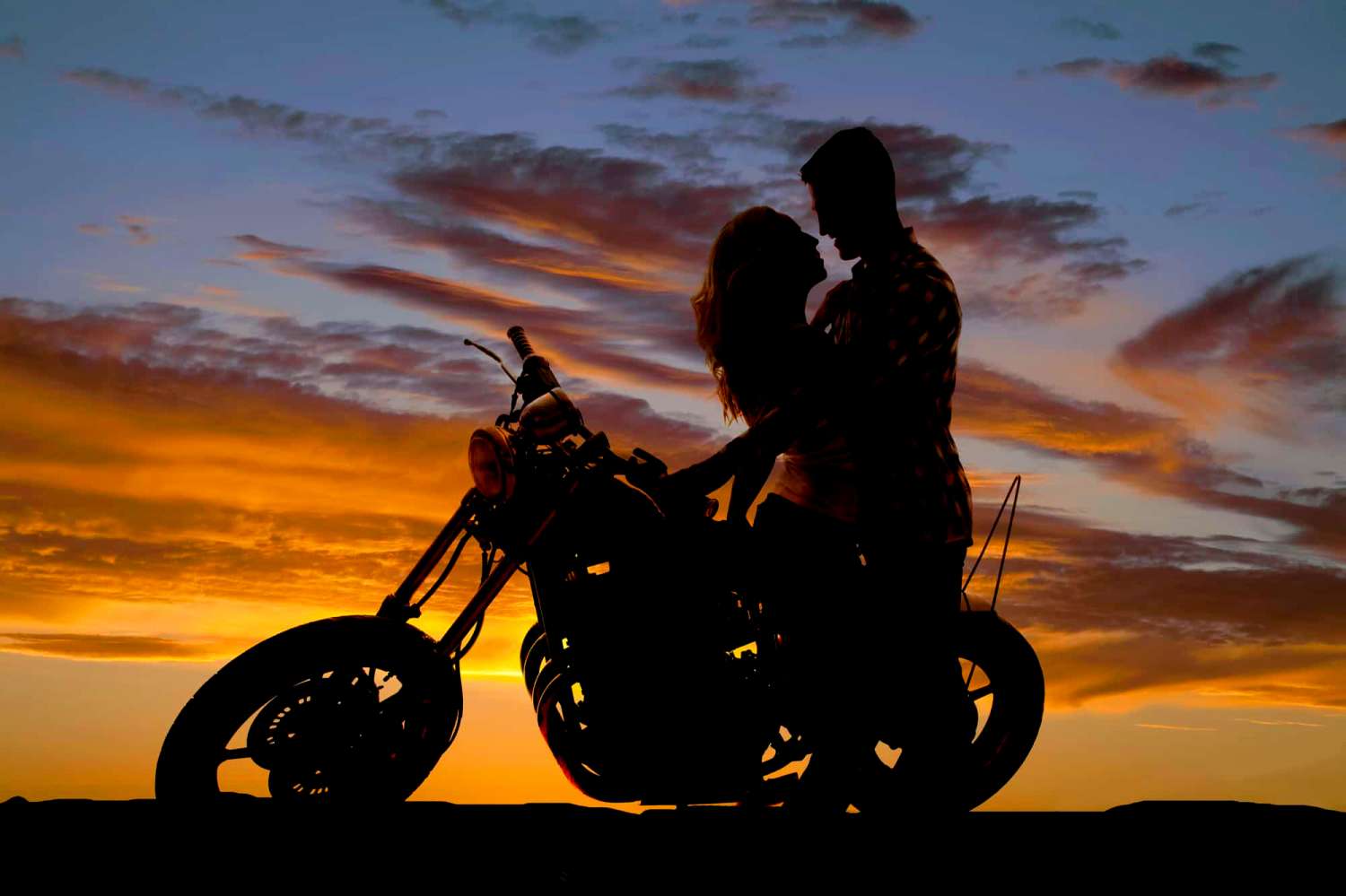 Девушка и мужчина на мотоцикле на закате