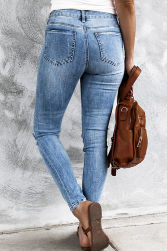 Голубые облегающие джинсы с дырками на коленях и высокой талией с застежкой на пуговицах