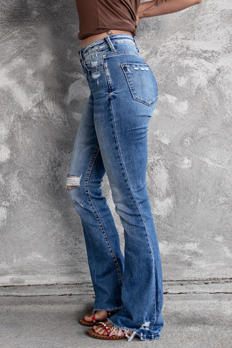 Голубые потертые джинсы-клеш с дыркой на колене