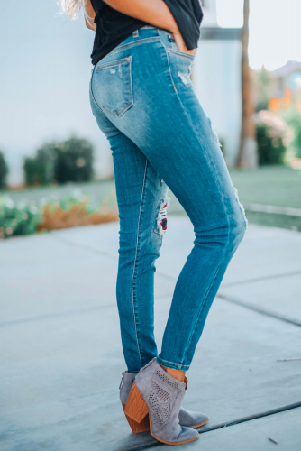 Светло-голубые потертые облегающие джинсы с дырками и красными клетчатыми заплатками