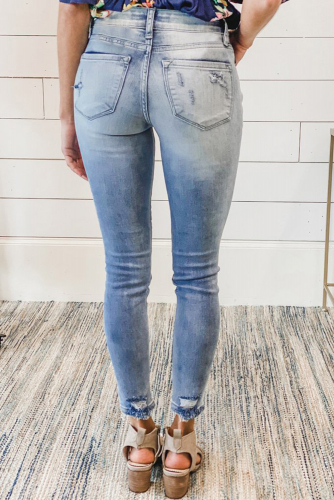 Светло-голубые потертые облегающие джинсы с дырками